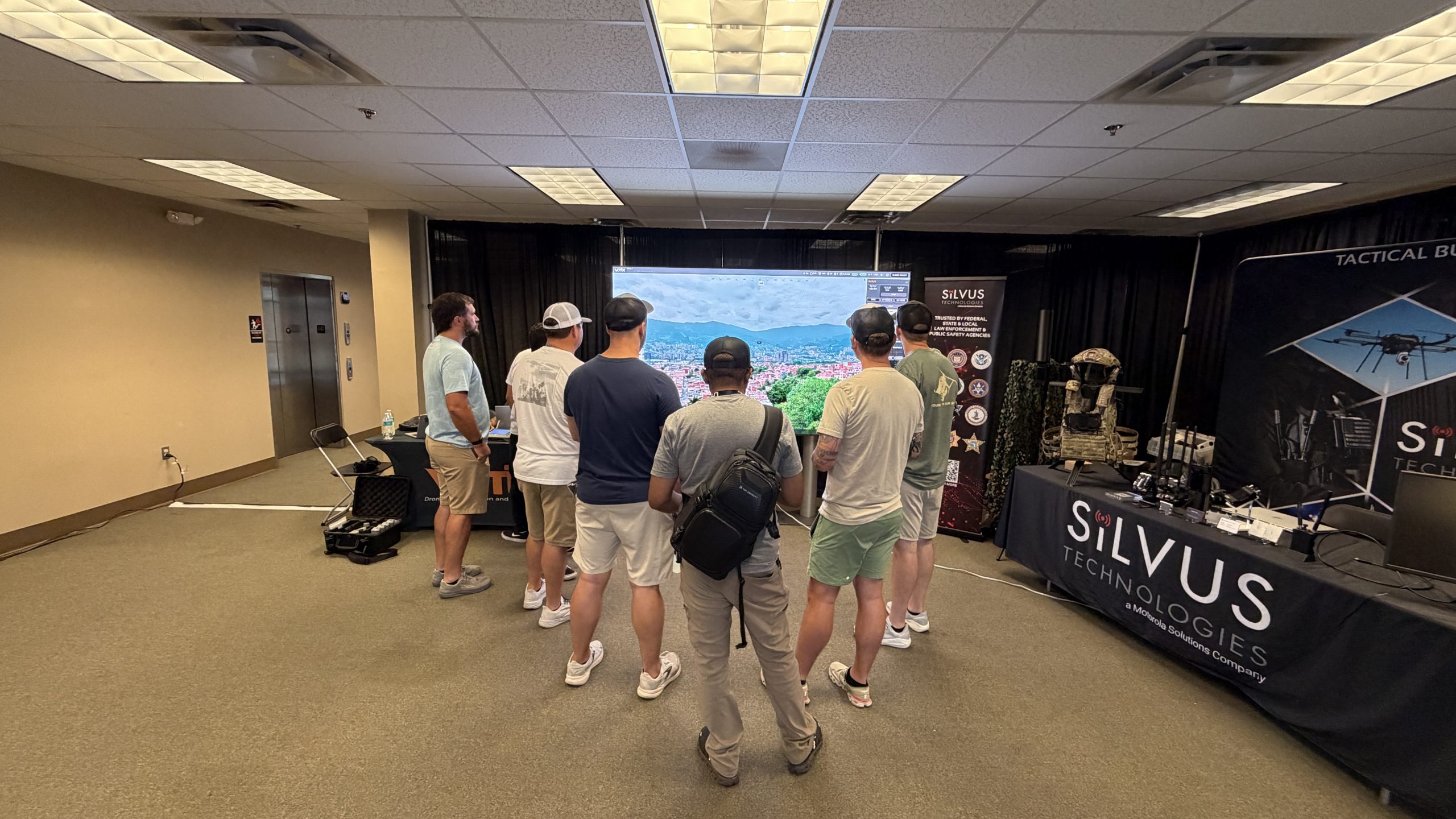UTAC 2026 attendees watching a live demonstration of the VOTIX Situation Rooms platform on a large screen